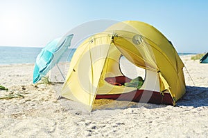 Yellow tent on the beach at bright sunny day