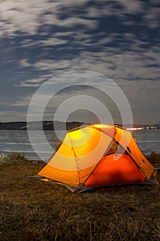 Yellow tent at night on the shore of lake Baikal in winter