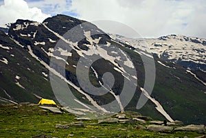 Yellow tent under snowy mountain