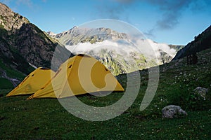 Yellow tents at Mulling campsite in Pin Bhaba pass trek in Shimla, Himalaya mountain range in north India