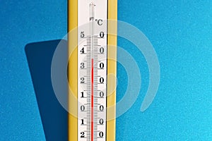 A yellow thermometer on a blue background.
