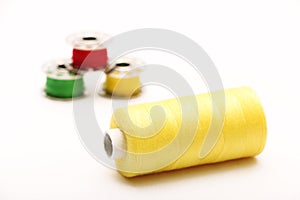 Yellow Thread with Bobbins in the Background