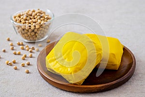 Yellow tofu on wooden plate and soy bean in bowl