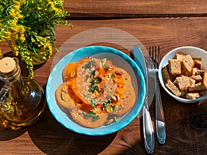 Yellow tomatoes salad with rye bread slices in blue ceramic bowl top view. Ripe fresh colorful vegetables mixed greens