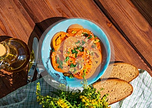 Yellow tomatoes salad with rye bread slices in blue ceramic bowl top view. Ripe fresh colorful vegetables mixed greens