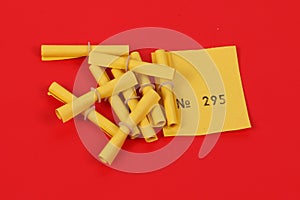 Yellow tombola tickets with a winning number are lying on a red ground in the studio