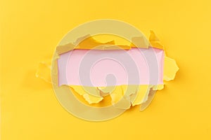 Yellow torned paper over pink