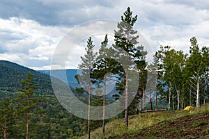 Yellow tourist tent on hillside. Cross country hiking, survival in wild