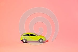 Yellow toy car on a pink background, a concept idea of a taxi and delivery of goods during quarantine