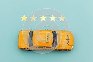 Yellow toy car Taxi Cab and 5 stars rating isolated on blue background. Smartphone application of taxi service for online