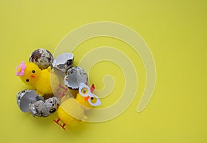 Yellow toy chickens hatched from an egg, on a yellow background. space for text. easter concept