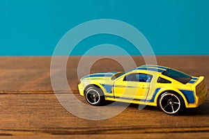 Yellow toy sports car on wooden table