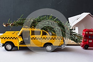 Yellow toy taxi on a tree trunk.