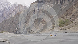 A yellow tractor digging sand in Hunza river