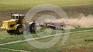 Yellow tractor preparing land for sowing.