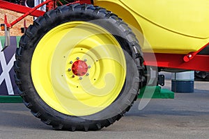 Yellow tractor wheel, close up. Agronomy, farming, husbandry concept