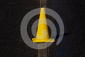 yellow traffic cone stand on road marker line