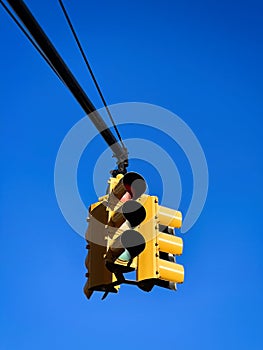 Yellow traffic light on a blue sky background