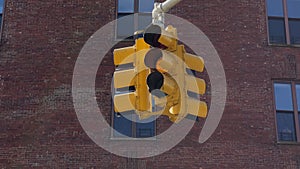 A yellow traffic light hangs at intersection in New York, USA. Red stop signal.