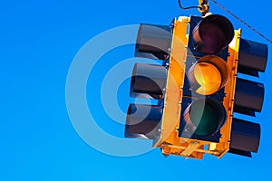 A yellow traffic light with a sky blue background