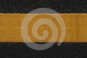 Yellow traffic lines on the dark asphalt road background