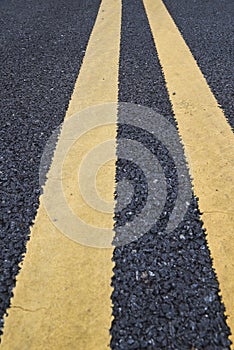 Yellow traffic lines marking on asphalt road