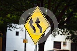 Yellow traffic sign with wavy black arrows