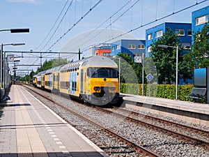 A yellow train is leaving a station.