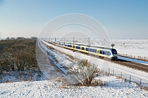 Yellow train in Dutch rural winter landscape