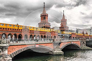 Yellow train on Oberbaum bridge, over river Spree in city Berlin at Germany