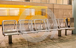 Yellow Train speeding behind metal Seats