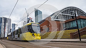 Yellow tram passing the Manchester Central Convention Complex