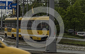 Yellow tram in Pilsen city on wet rainy street