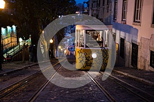 Yellow tram on the street of Lisbon. Lisbon`s Gloria funicular at night classified as a