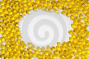 Yellow transparent pills on a white background with a copy space in the center, in the form of a frame. Pills with vitamin D3