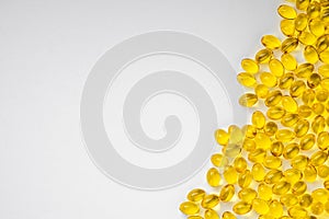 Yellow transparent pills on a white background with a copy space left. Pills with vitamin D3