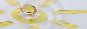 Yellow transparent vitamin D pill lying on drawn sun closeup