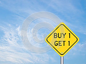 Yellow transportation sign with word buy 1 get 1 on blue cloud sky background