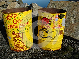 Yellow trash barrels with environmental graffiti