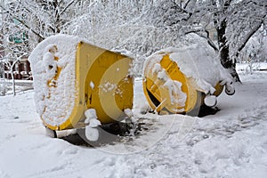 Yellow trash can covered with snow