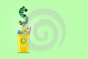 Yellow trash can. With a recycling icon for paper, and sign dollar made from leaves.On a yellow background. Copy space