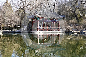 Yellow trees and blue sky are reflected in the quiet river