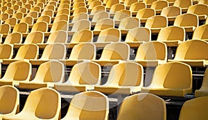 yellow tribunes. seats of tribune on sport stadium. empty outdoor arena. concept of fans. chairs for audience. cultural
