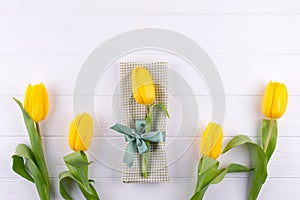 Yellow tulips on a napkin tied with a bow. Background for menu. Flat lay,