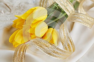 Yellow tulips, perfume and gold ribbon