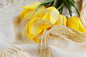 Yellow tulips, perfume and gold ribbon