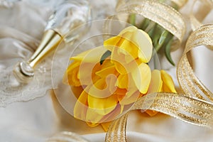 Yellow tulips, perfume and gold ribbon