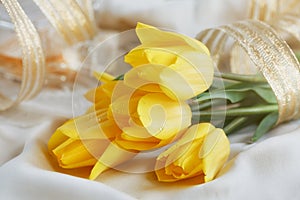 Yellow tulips, perfume and gold ribbon