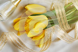 Yellow tulips, perfume and gold ribbon