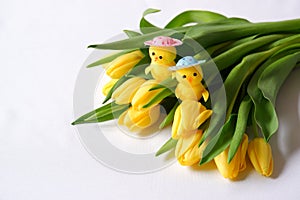 Yellow tulips white background two toy chickens heads